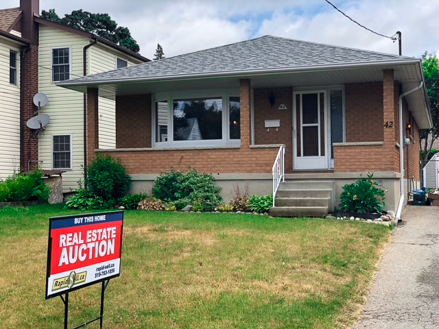 House with auction sign on lawn